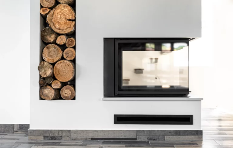Moderner Kamin mit großem Glasfenster und stilvoller Holzlagerung an der Wand.